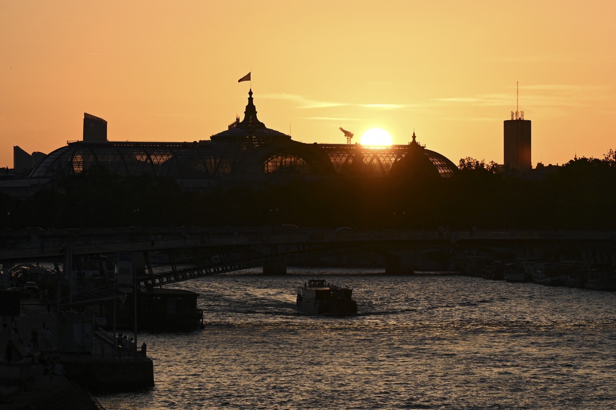 A tourist boat sails along the Seine river at sunset with the Grand Palais in the background, in Paris on 26 May 2026. (Photo by Christophe DELATTRE / AFP)
