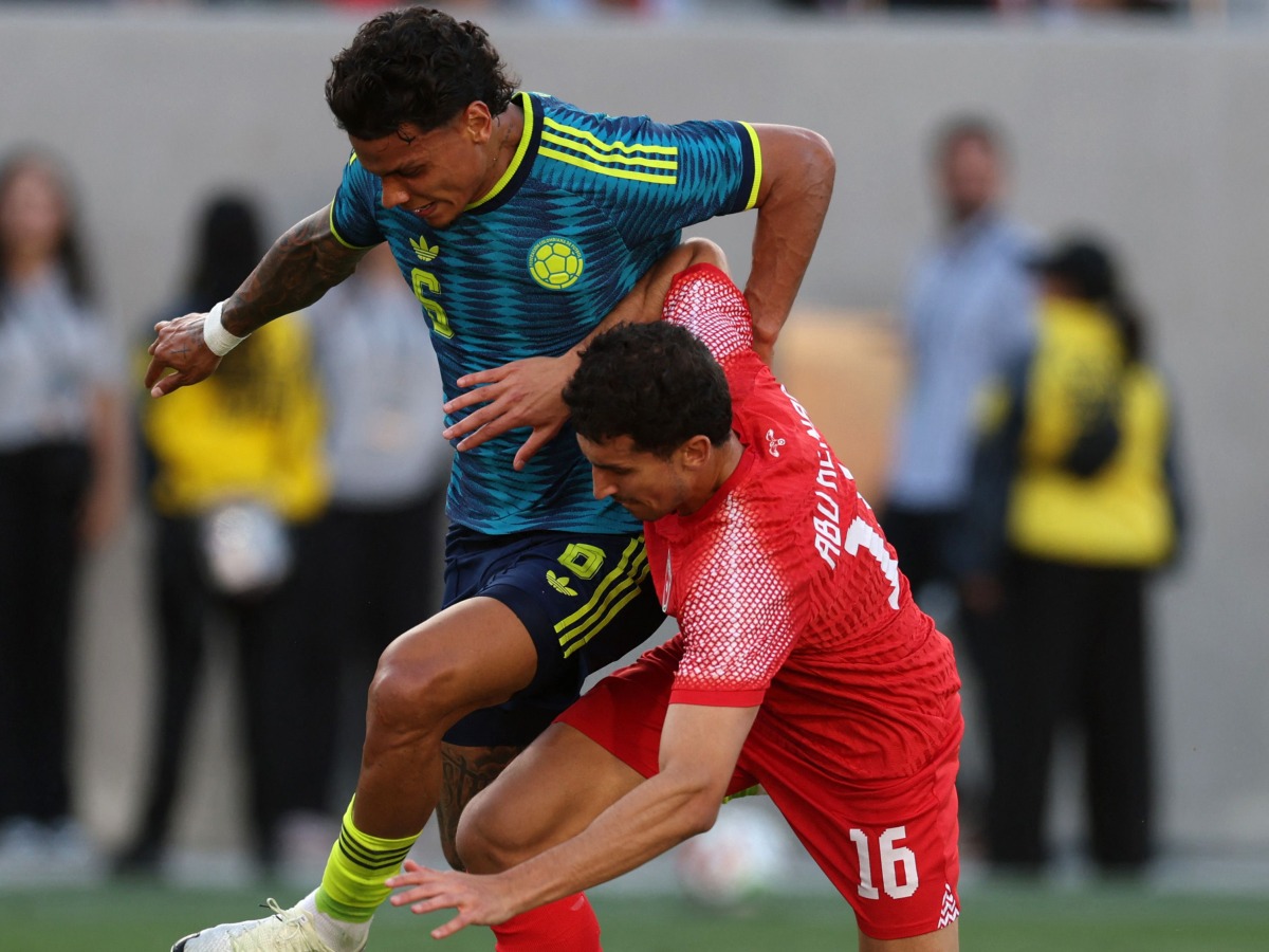 Richard Rios of Colombia fights for the ball with Mohammad Abualnadi of Jordan.