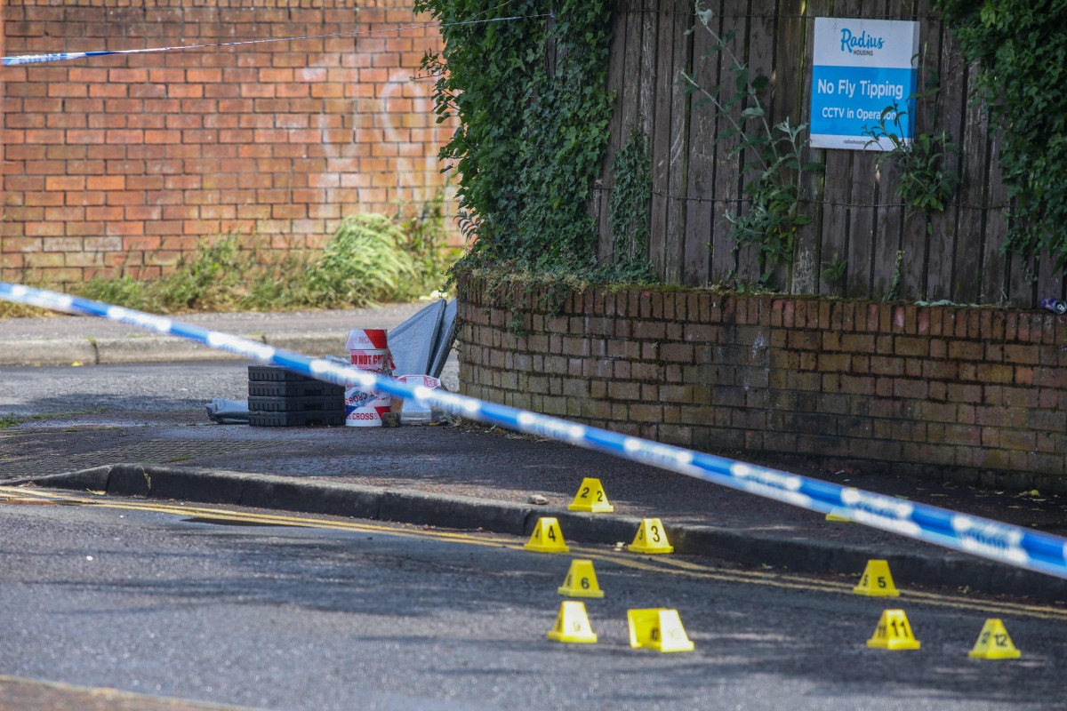 Police forensic marks are pictured behind a cordon at the scene of a stabbing on Kinnaird Avenue in north Belfast, Northern Ireland, on June 9, 2026. Photo by Paul Faith / AFP