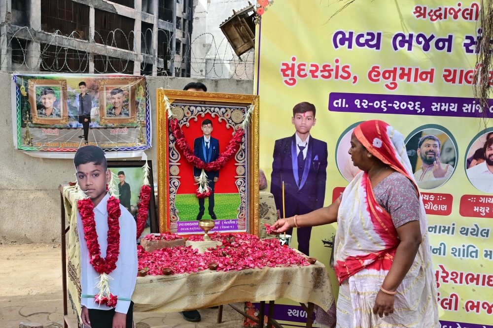 A family member of Air India plane crash victim Akash Patni pays tribute at the crash site on the first anniversary of the disaster in Ahmedabad on June 12, 2026. (Photo by Shammi Mehra / AFP)