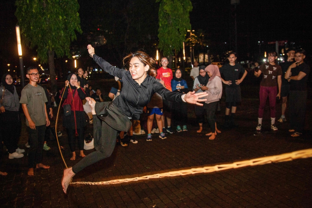 A member takes part in lompat tali karet (jump rope), an Indonesian children's game, at the Gelora Bung Karno Stadium compounds in Jakarta on May 22, 2026. (Photo by Aditya Irawan / AFP) 