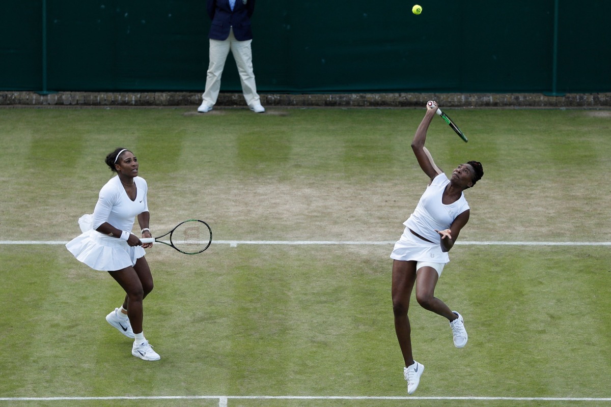 A file photo of the sisters Serena Williams (L) and Venus Williams playing against Belgium's Elise Mertens and Belgium's An-Sophie Mestach during their women's doubles second round match on the sixth day of the 2016 Wimbledon Championships at The All England Lawn Tennis Club in Wimbledon, southwest London, on July 2, 2016. Photo by ADRIAN DENNIS / AFP