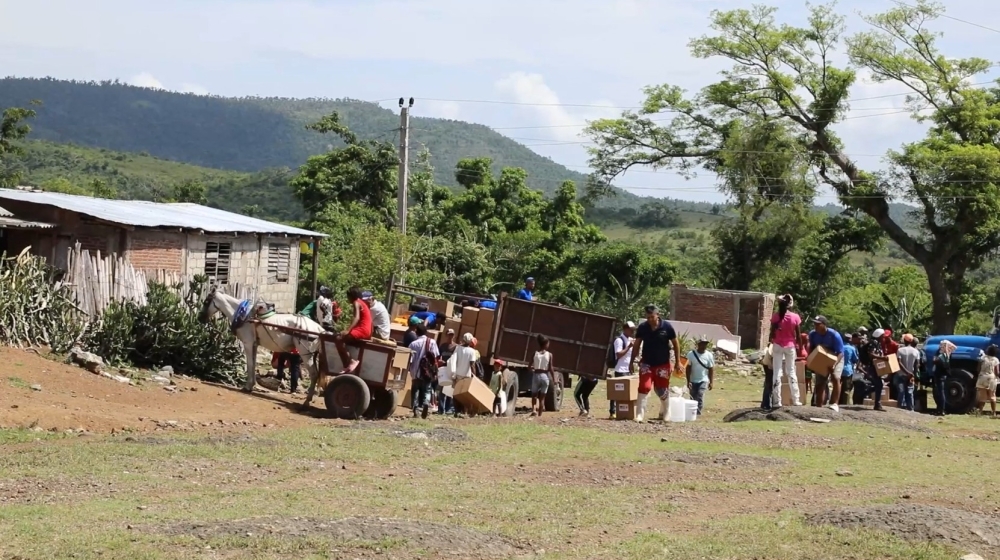 This AFPTV screengrab shows residents affected by Hurricane Melissa on October 29, 2025 receiving humanitarian aid from Caritas volunteers, on June 13, 2026. (Photo by AFPTV STRINGER / AFP)