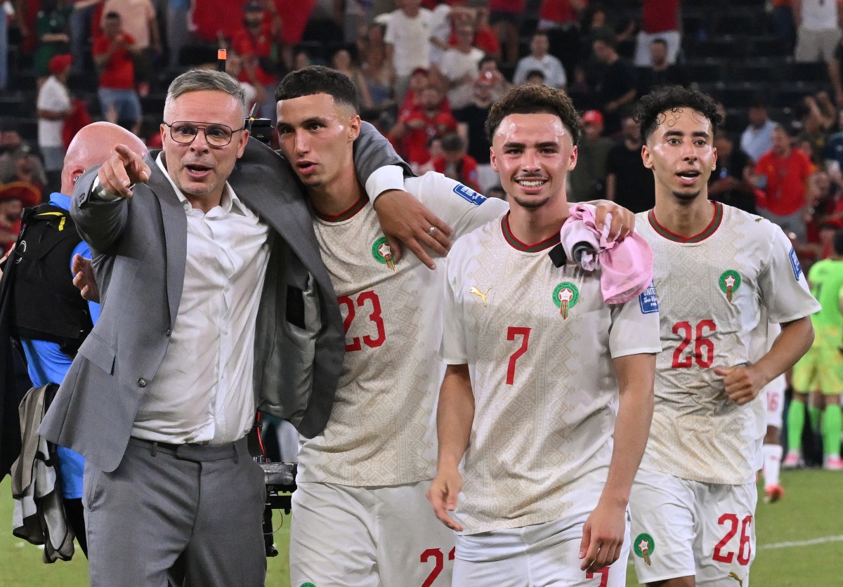 Morocco’s head coach Mohamed Ouahbi (left) celebrates with his players after they defeated the Netherlands. (AFP)