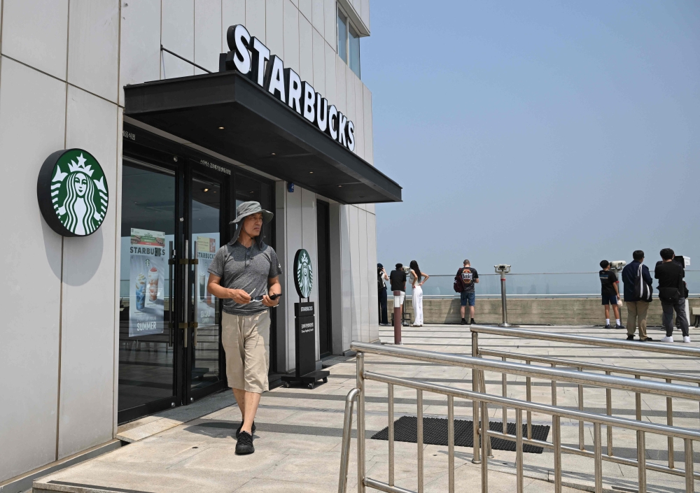 A visitor walks past a Starbucks store offering a view of North Korea at a South Korean observation deck at Aegibong Peace Ecopark in Gimpo on July 1, 2026. Photo by Jung Yeon-je / AFP