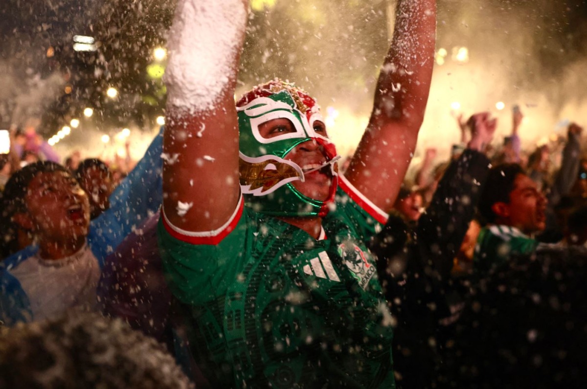 A masked Mexican football fan reacts as they watch the 2026 FIFA World Cup Round of 16 football match between Mexico and England at the Angel of Independence in Mexico City on July 5, 2026. (Photo by Claudia Rosel / AFP)