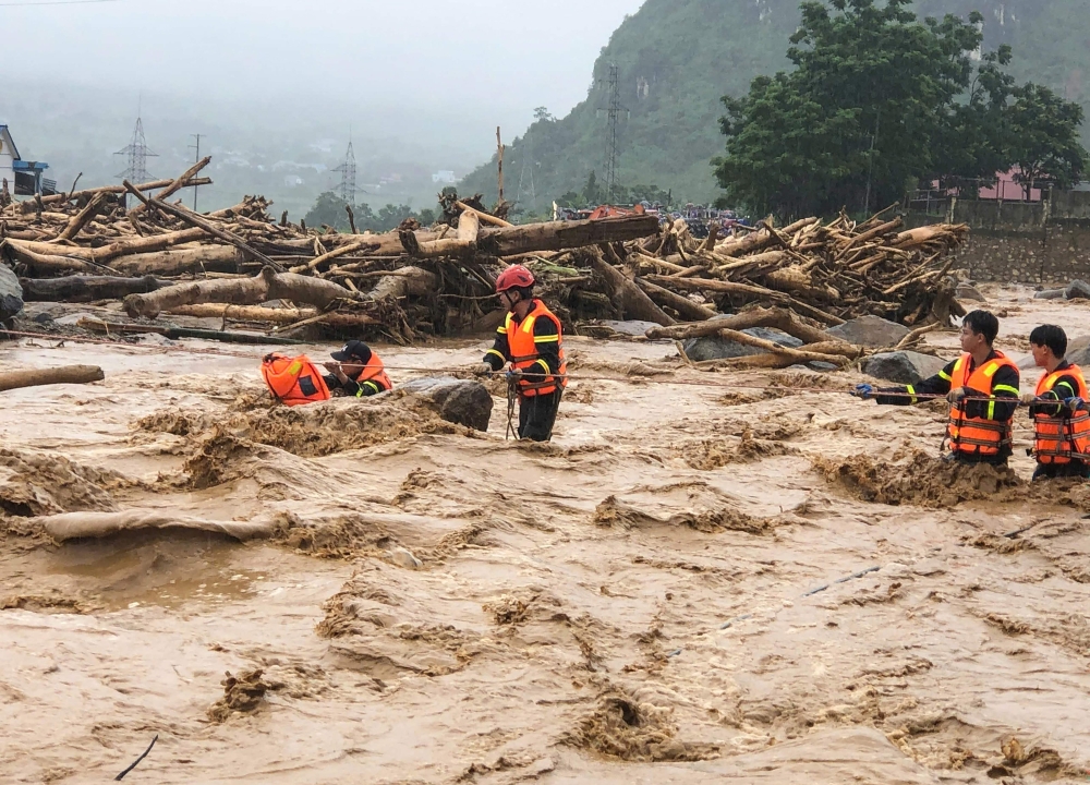 This photo taken and released by Vietnam News Agency (VNA) on July 17, 2026, shows rescue workers addressing the aftermath of flash floods in Muong Than Commune, Lai Chau Province, northern Vietnam. (Photo by Vietnam News Agency (VNA) / AFP)