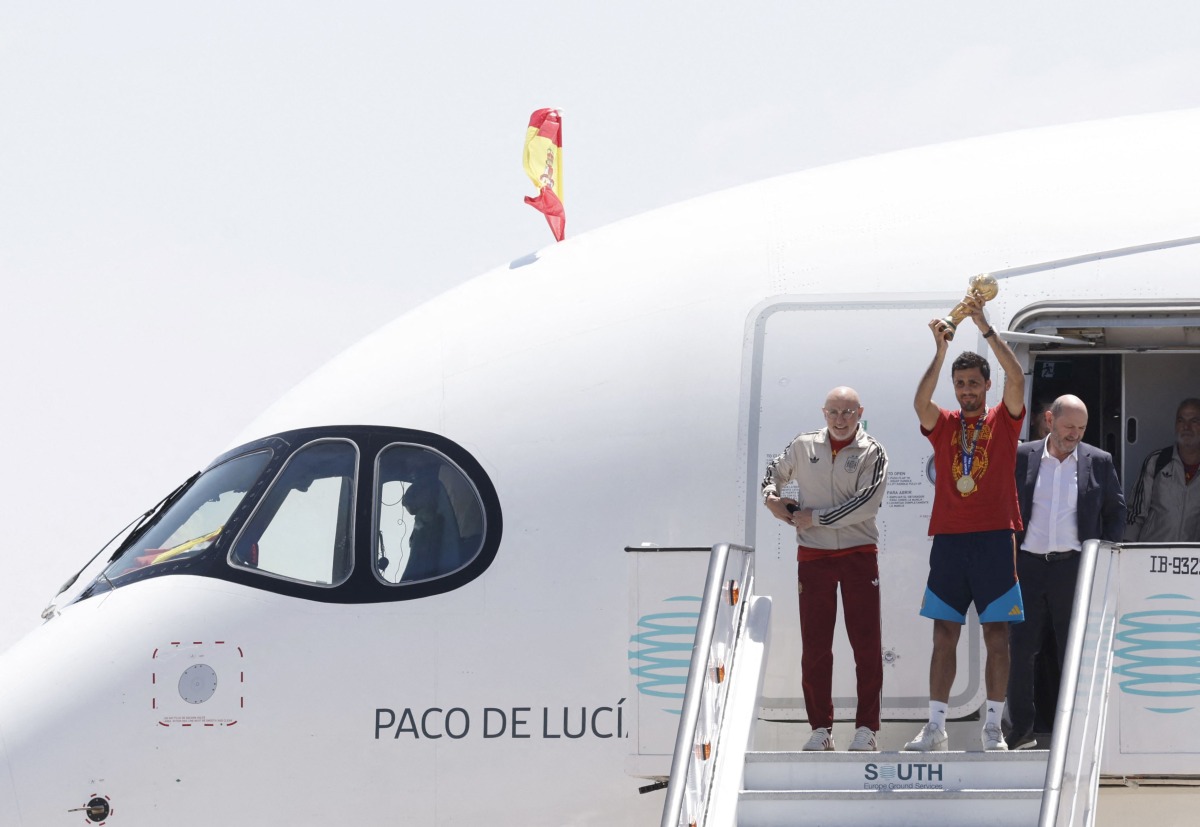 Spain’s coach Luis de la Fuente (left) and captain Rodri hold the World Cup trophy upon their arrival in Madrid Barajas’ airport. 