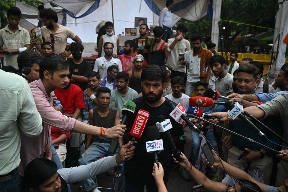 Cockroach Janta Party (CJP) founder Abhijeet Dipke speaks to the media during a protest demanding the resignation of India's Education Minister Dharmendra Pradhan over alleged NEET exam irregularities, in New Delhi on July 21, 2026. (Photo by Arun Sankar / AFP)