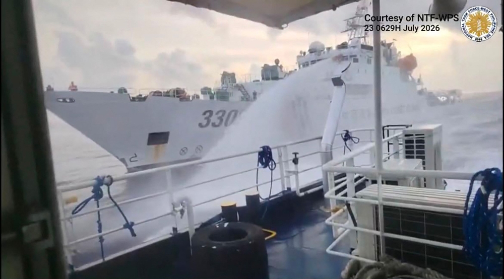 This handout screengrab taken on July 23, 2026 and released by the Philippine Coast Guard (PCG) shows a Chinese Coast Guard ship (back) water canonning a Philippines' Bureau of Fisheries and Acquatic Resources (BFAR) ship near Scarborough Shoal, in the disputed South China Sea. (Photo by Handout / Philippine Coast Guard (PCG) / AFP) /