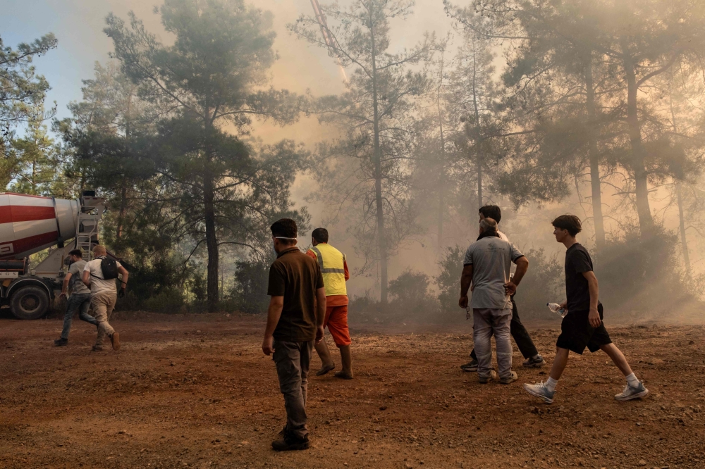 Volunteers and firefighters battle a wildfire in Fethiye, in the province of Mugla, southwestern Turkey on July 30, 2026. (Photo by Murat Kocabas / AFP)