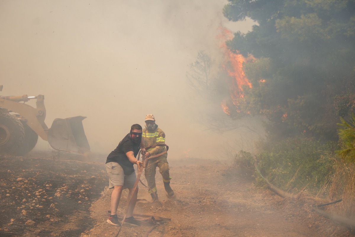 Volunteers and firefighters work to extinguish a wildfire in the Veniza area, west of Athens, in the Viotia region, on August 2, 2026. Photo by Aris Oikonomou / AFP