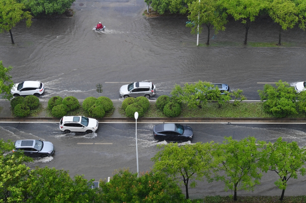 Vehicles drive through a waterlogged street in Wuxi, east China's Jiangsu Province, Aug. 10, 2026. (Photo by Huan Yueliang/Xinhua)