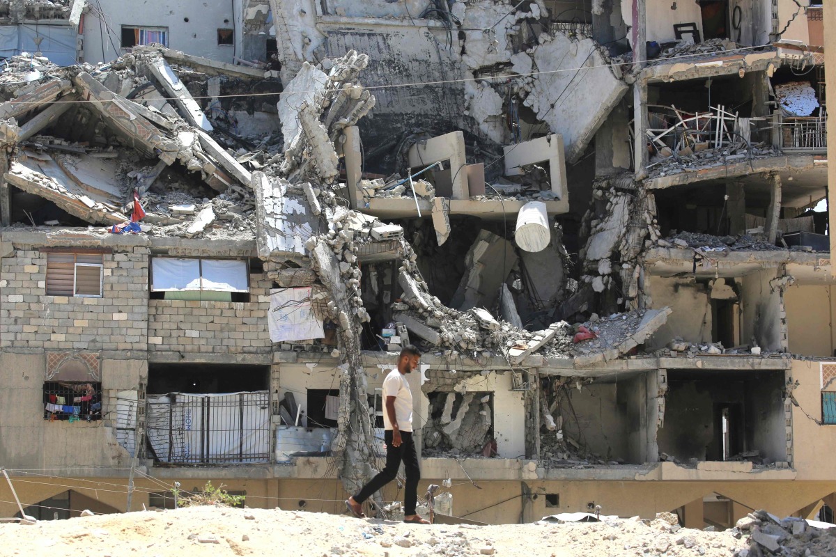 :An internally displaced Palestinian man walks past the rubble of buildings destroyed by Israeli forces in Khan Yunis southern Gaza Strip on August 11, 2026. (Photo by Bashar Taleb / AFP)