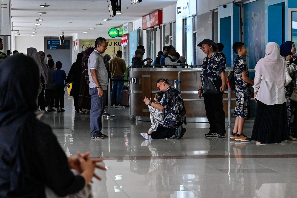 Passengers wait at a terminal of Iskandar Muda airport in Blang Bintang on September 6, 2026. Indonesia halted operations at its main international airport outside Jakarta on September 6, after ash spewed from the Anak Krakatoa volcano more than 150 kilometres away, impacting thousands of passengers. (Photo by CHAIDEER MAHYUDDIN / AFP)
