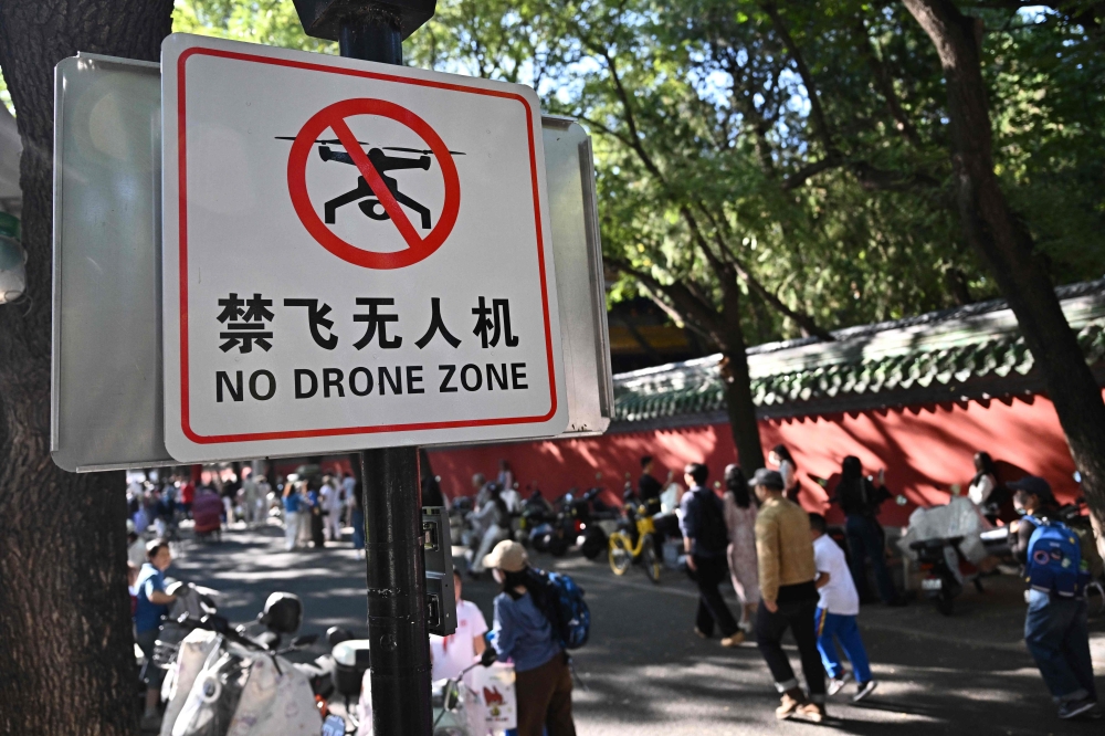People walk past a sign reading 