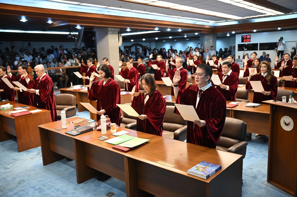 (Files) Philippine senators take their oath as jurors in the impeachment trial of Vice President Sara Duterte at the plenary hall of the Senate in Manila on May 18, 2026. (Photo by Ted Aljibe / AFP)