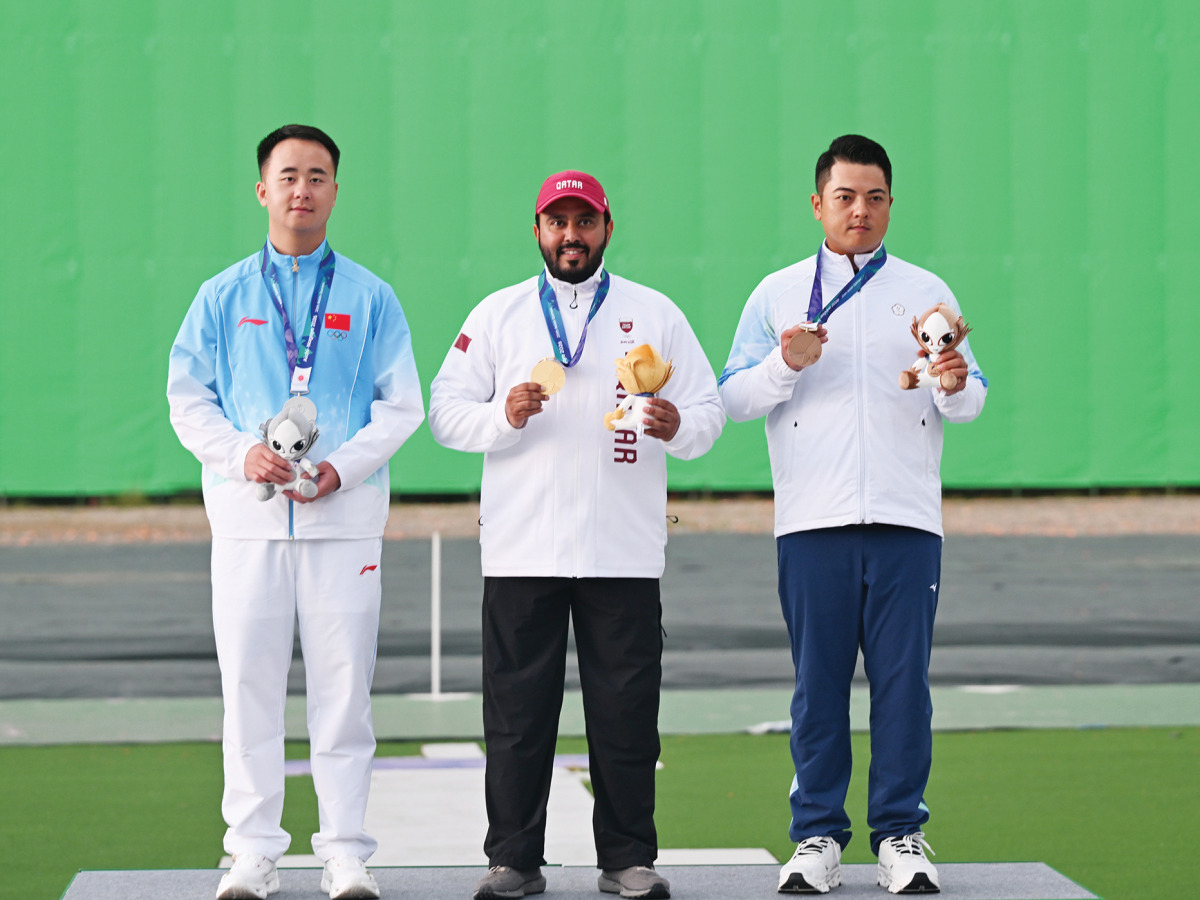 Individual skeet gold medalist Rashid Saleh Al-Athba (centre) of Qatar, silver medallist L Jianlin (left) of China and bronze winner L Meng-Yuan of Chinese Taipei celebrate on the podium. (XINHUA)