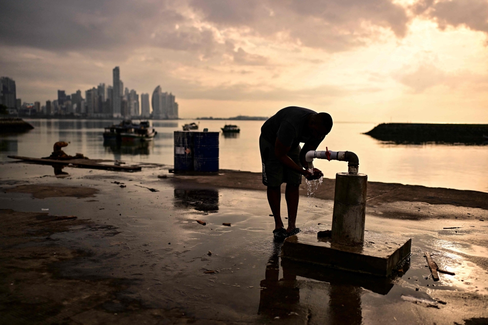 A fisherman washes at the fishing terminal in Panama City in the early hours of the morning on September 24, 2026. (Photo by Martin Bernetti / AFP)