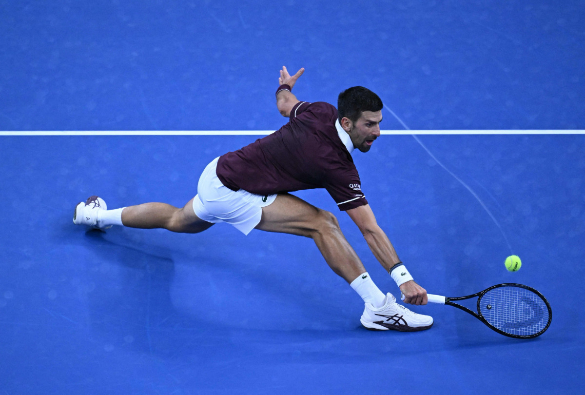 Novak Djokovic hits a return to Daniil Medvedev.