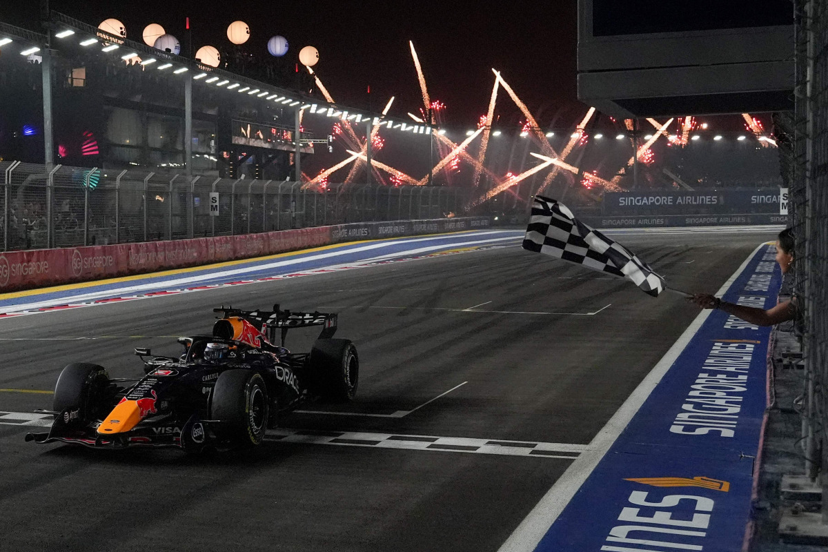 Red Bull Racing's Dutch driver Max Verstappen crosses the chequered flag at the finish line to win the Formula One Singapore Grand Prix at the Marina Bay Street Circuit in Singapore on October 11, 2026. (Photo by Ng Han Guan / POOL / AFP)