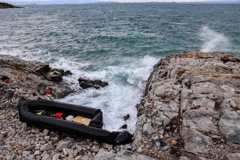 (Files) This photograph taken on January 10, 2024, shows an inflatable dinghy washed up on the rocky shores of Agios Georgios, east of the Greek island of Lesbos in the Aegean Sea. (Photo by Manolis Lagoutaris / AFP)