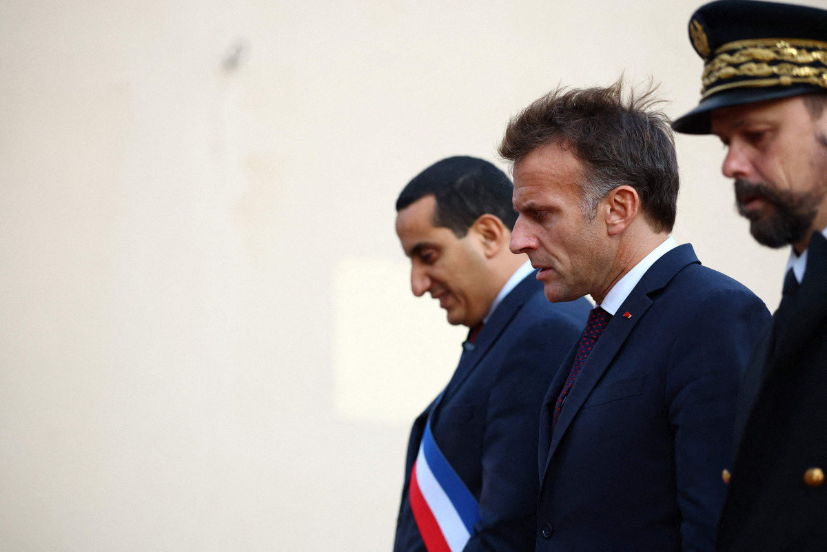 French President Emmanuel Macron (C) walks with Mayor of Trappes Ali Rabeh (L) during a visit following a shooting in Trappes, near Paris on October 23, 2026. (Photo by Hannah McKay / POOL / AFP)